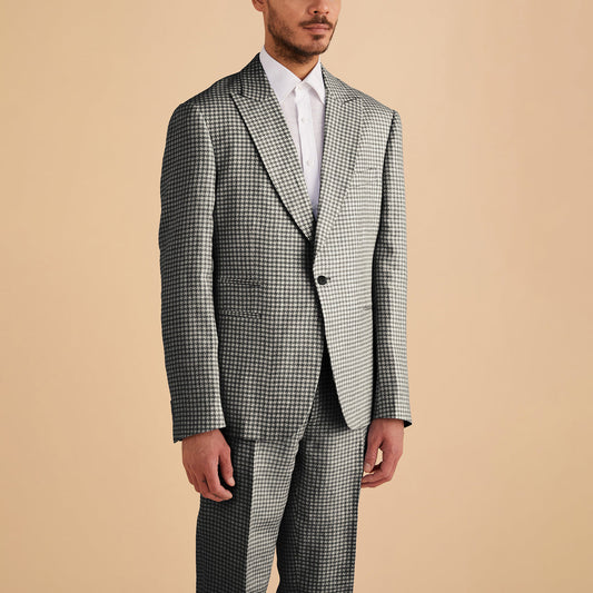 A man wears the Inserch Linen Houndstooth Blazer BL269-00041 in black & white by Inserch, paired with a white dress shirt, standing against a plain beige background.