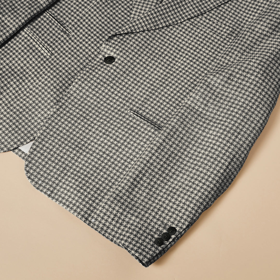 A man wears the Inserch Linen Houndstooth Blazer BL269-00041 in black & white by Inserch, paired with a white dress shirt, standing against a plain beige background.