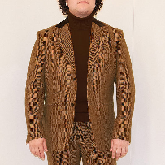 A person wearing the Inserch Herringbone Blazer BL273-24 Chocolate by Inserch, paired with a brown turtleneck, stands against a plain light background.
