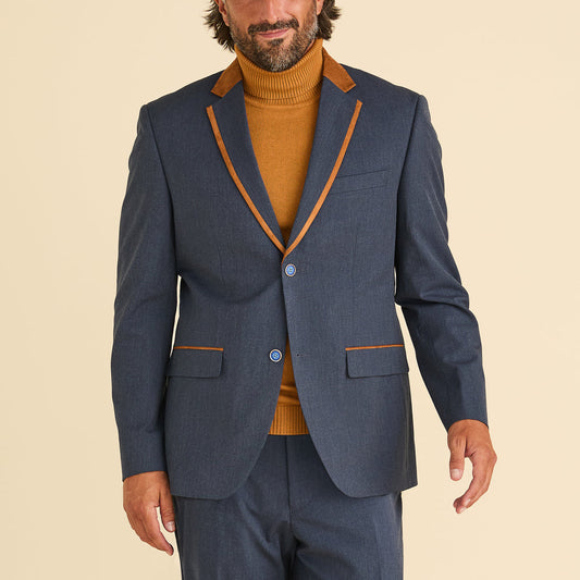 Man wears the Inserch Chambray Blazer BL274-10 in denim blue by Inserch over a mustard turtleneck, standing against a plain beige background.