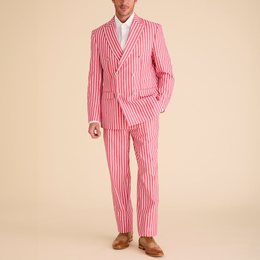 A man wears the Inserch Seersucker Wide Stripe Suit BL507-00030 Red by Inserch, paired with a white shirt and brown dress shoes, standing against a beige background.
