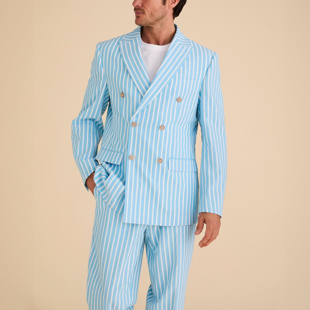 A man wearing the Inserch Seersucker Wide Stripe Blazer BL507-00183 Blue Mist with a white shirt stands against a plain beige background.