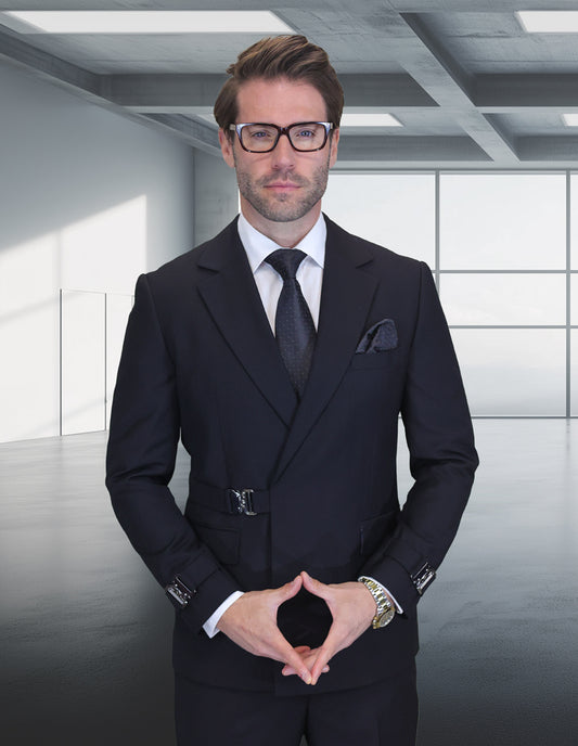 A man in the STATEMENT CLOTHING | BOLANZO-BLACK modern fit double-breasted suit and glasses stands in a minimalist office with large windows and geometric ceiling panels.