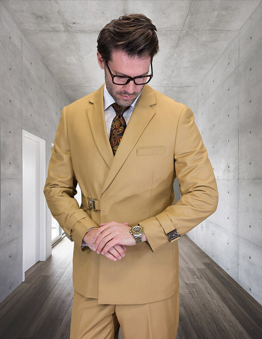 A man in the STATEMENT CLOTHING | BOLANZO-CAMEL suit by Statement Clothing, paired with a patterned tie, stands in a modern concrete hallway adjusting his watch while looking down.