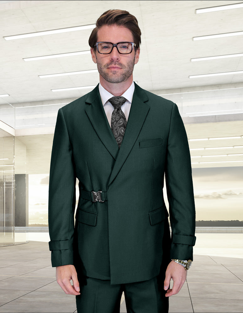 A man wearing the STATEMENT CLOTHING | BOLANZO-HUNTER suit by Statement Clothing, paired with a patterned tie and glasses, stands indoors against a modern, minimalist background.