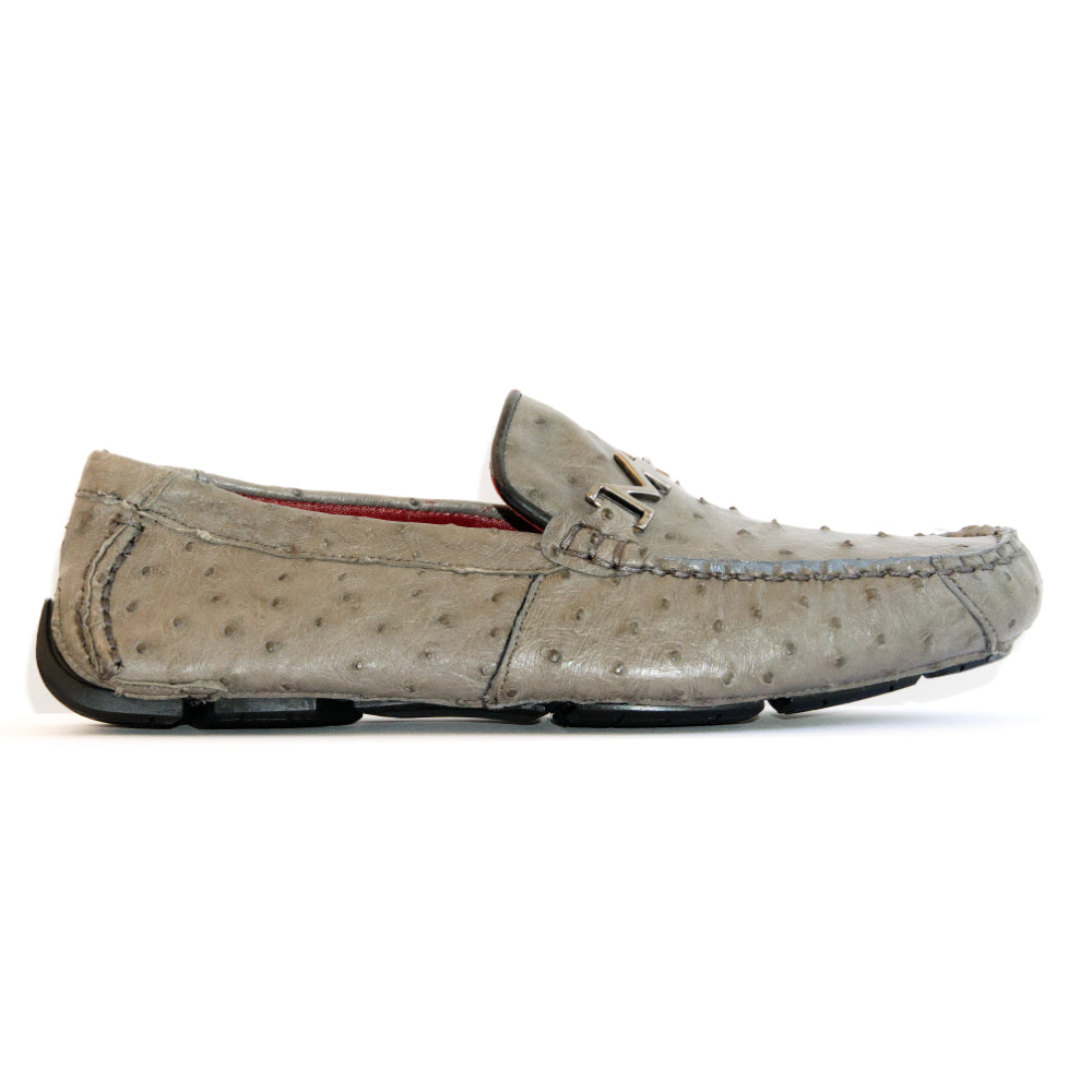 A pair of Bolonia Gray luxury moccasin loafers by Marco Di Milano, featuring a light gray textured surface, metal buckle detail, and black rubber soles, displayed against a white background.