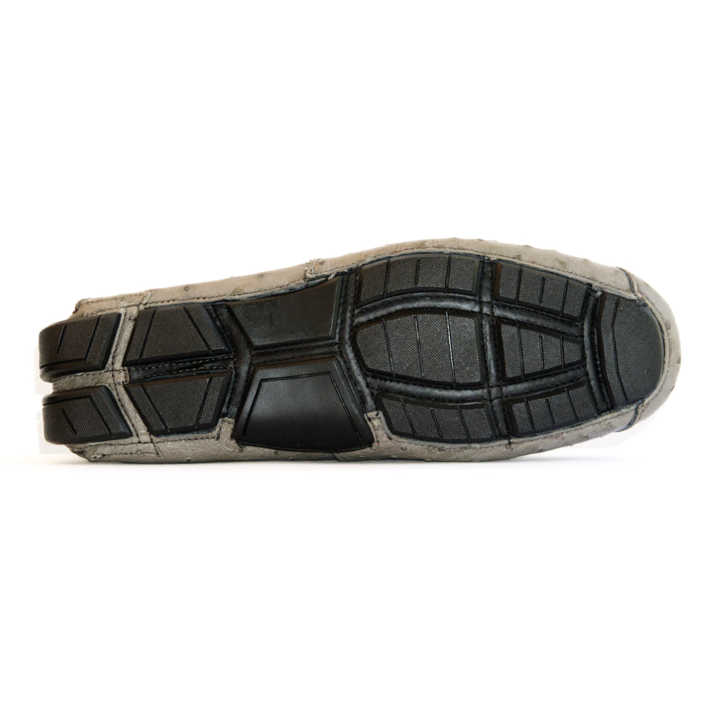 A pair of Bolonia Gray luxury moccasin loafers by Marco Di Milano, featuring a light gray textured surface, metal buckle detail, and black rubber soles, displayed against a white background.