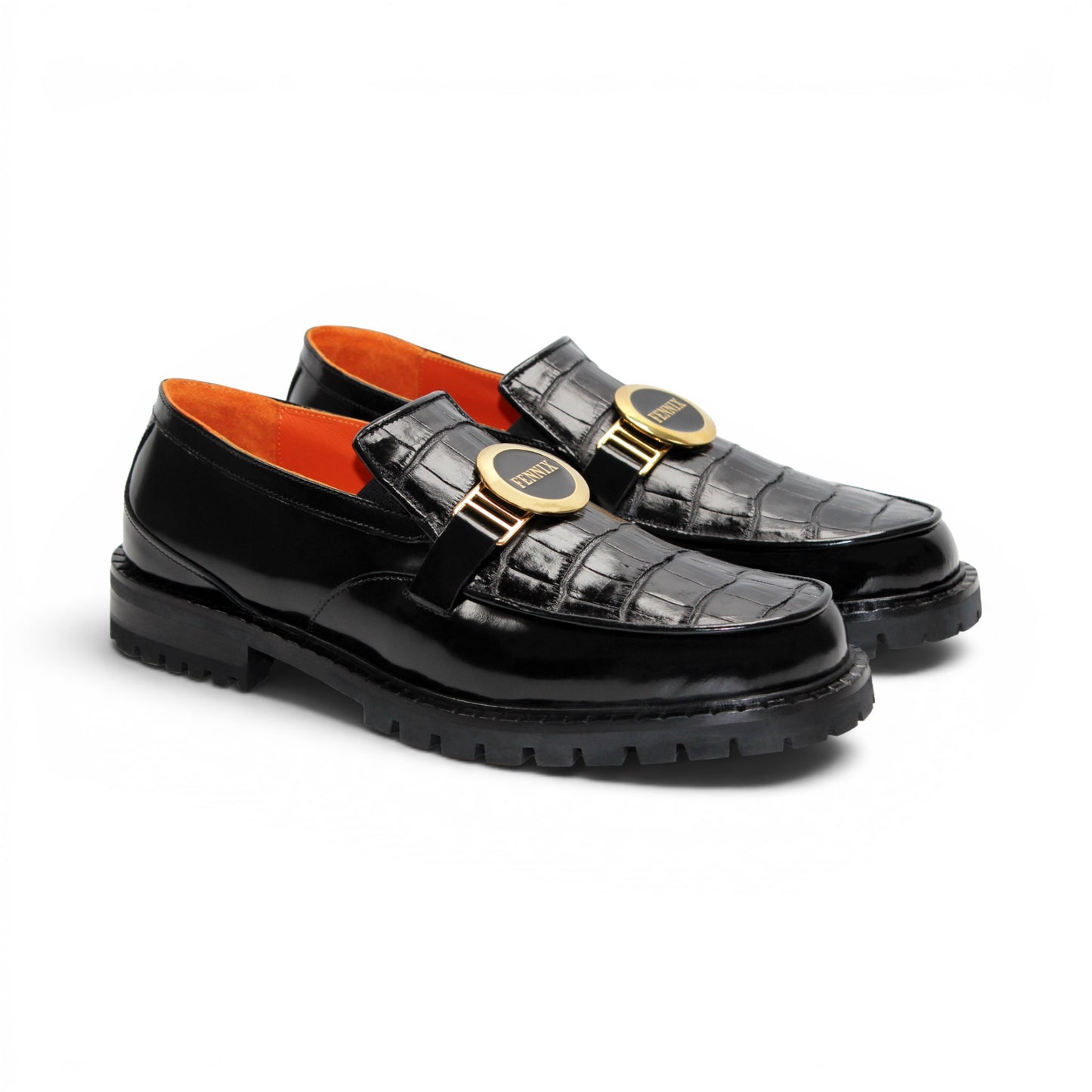 The Fennix Brant Black by Fennix of Italy is an Italian-crafted black patent loafer featuring a textured pattern, thick ridged sole, gold hardware buckle detail, and an orange inner lining, displayed in profile against a white background.