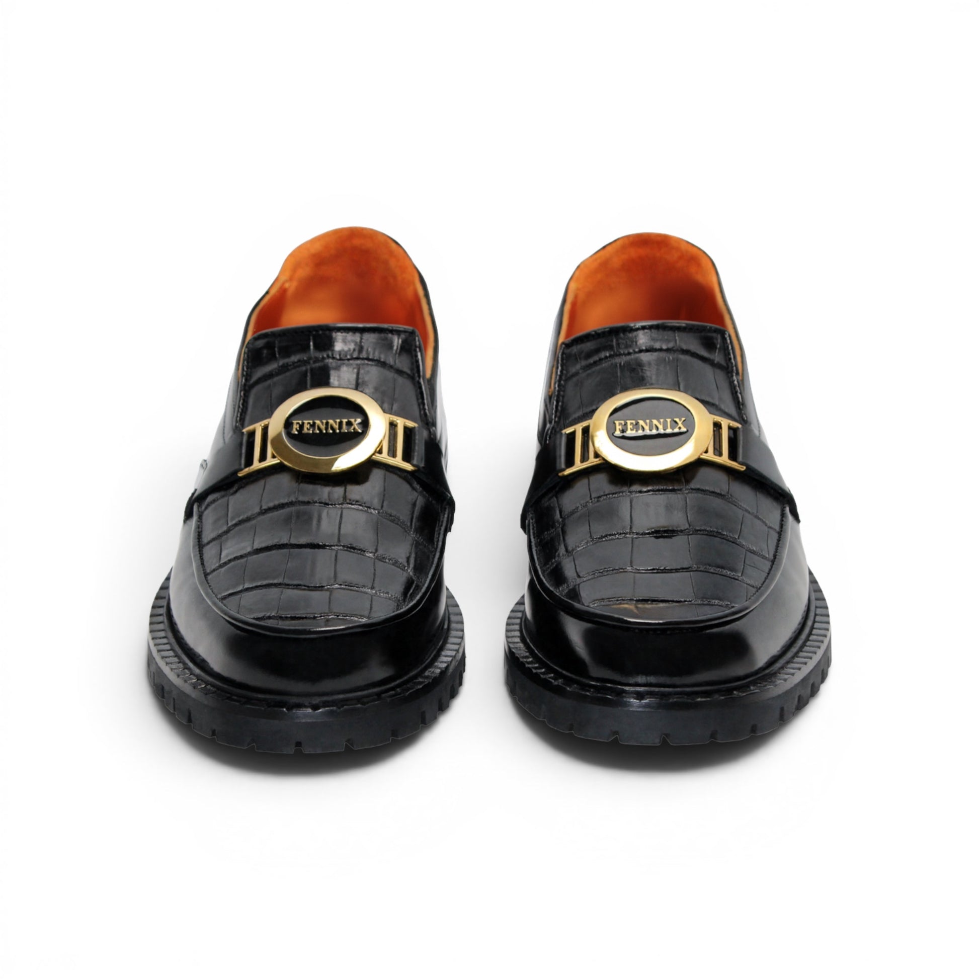 The Fennix Brant Black by Fennix of Italy is an Italian-crafted black patent loafer featuring a textured pattern, thick ridged sole, gold hardware buckle detail, and an orange inner lining, displayed in profile against a white background.