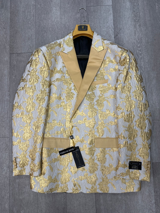 The Insomnia INSOMNIA MZS-522 GOLD Blazer features a white and gold floral pattern with gold lapels and pocket detailing, shown on a hanger against a wooden floor. Final sale—no returns.