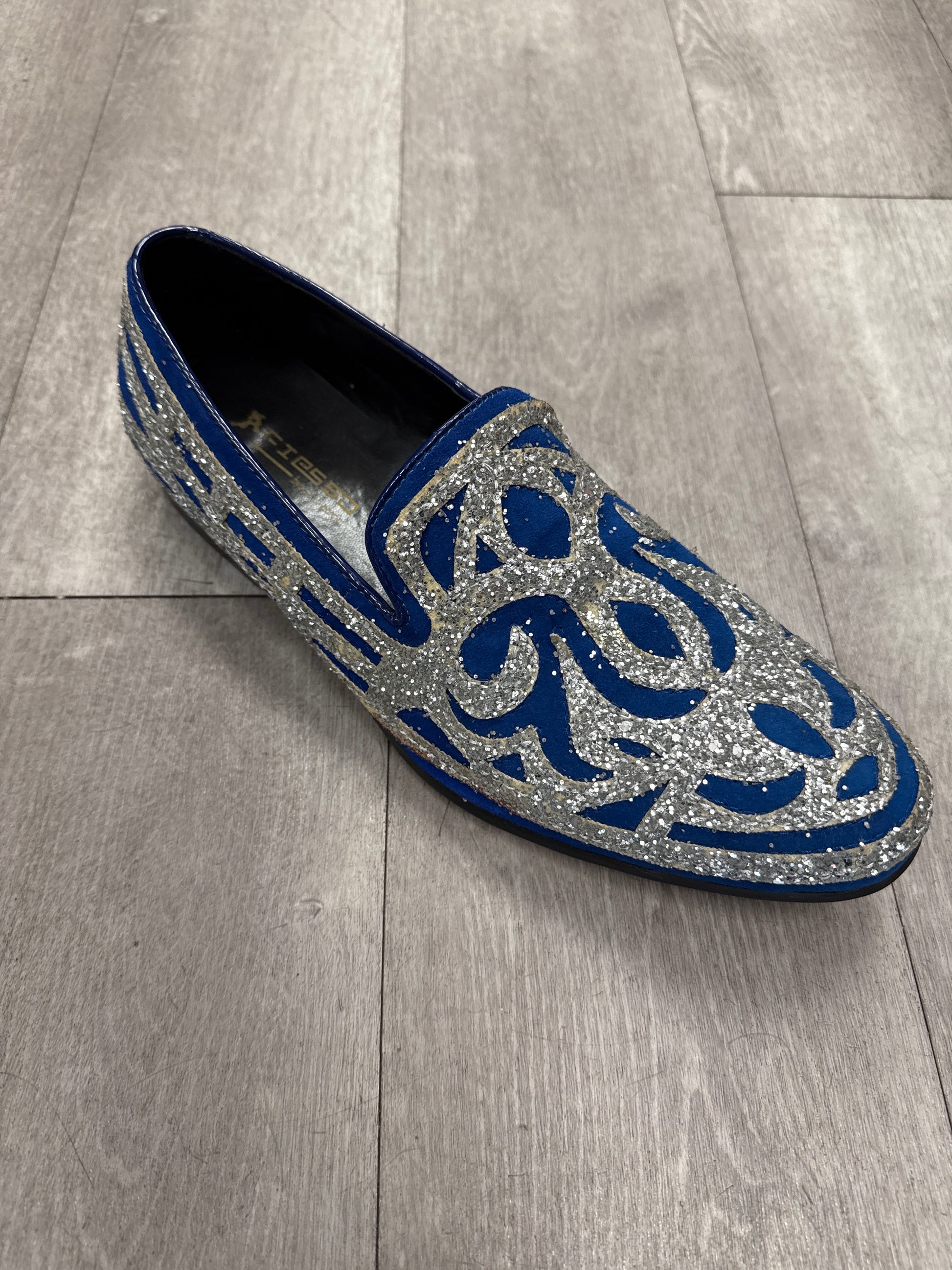 Fiesso Shoe 100, size 8 only, features silver glitter and blue swirl patterns. Displayed on a gray wooden floor. FINAL SALE—NO EXCHANGE, NO RETURN.