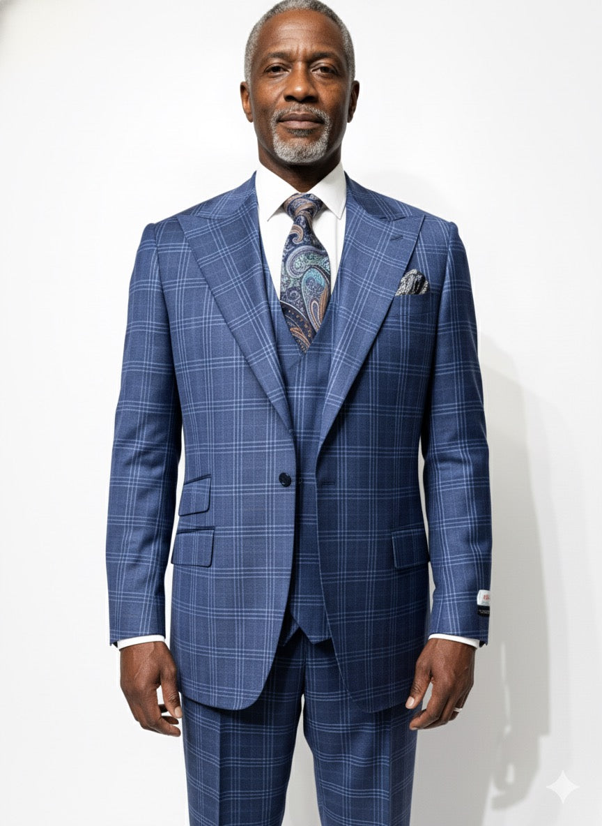 An older man in a Tiglio Rosso Orvietto Blue Plaid Semi Wide Leg suit (TL5074) with matching vest, white shirt, paisley tie, and pocket square stands against a plain white background.