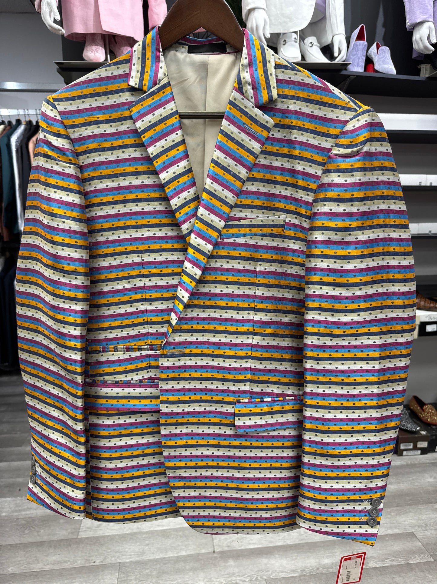 The EJ SAMUEL JACKET 23 CLEARANCE is a blazer featuring horizontal multicolored stripes and small polka dots, shown on a hanger in a clothing store. Please note: this item is final sale—no exchanges or returns.