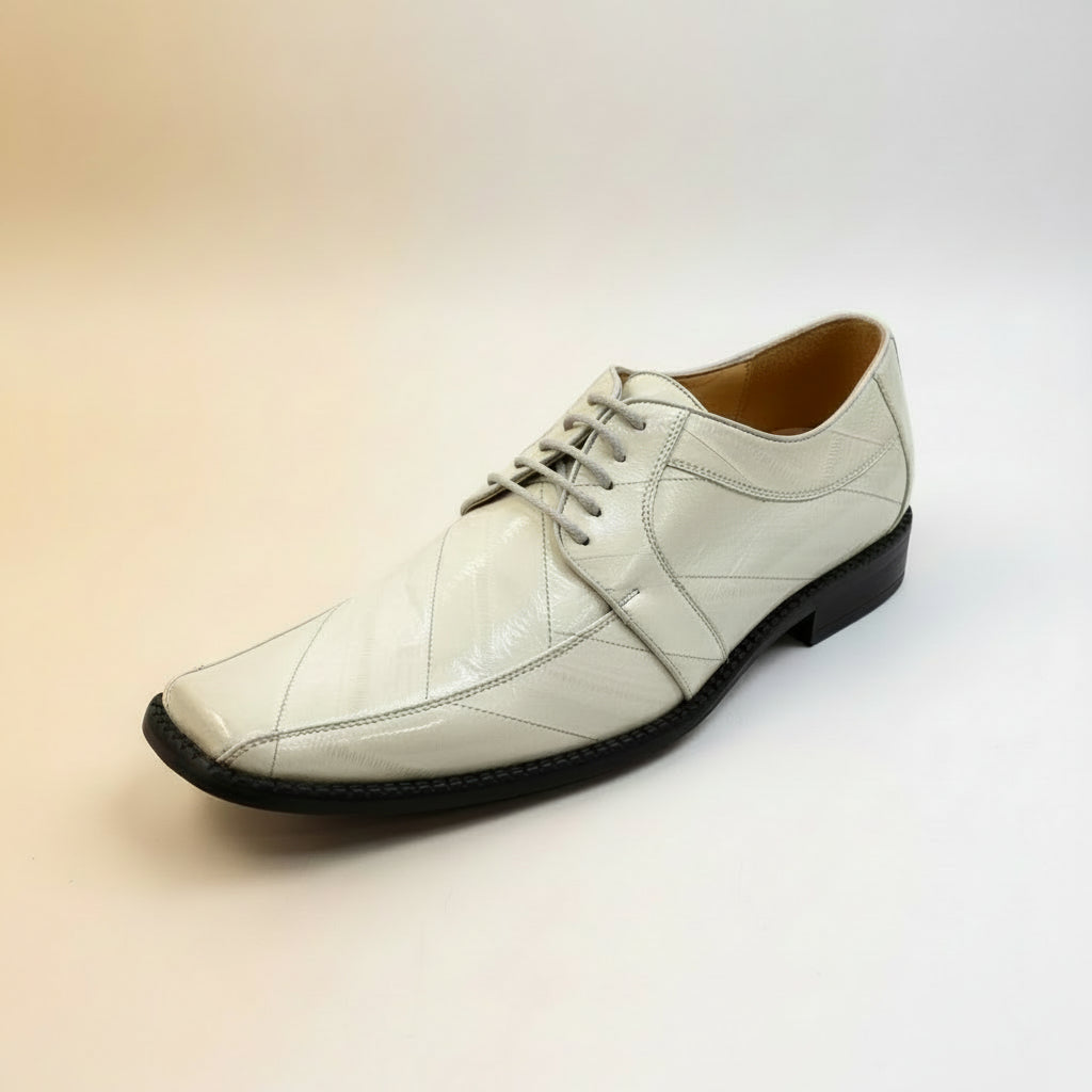 An off-white, glossy Fiesso Shoe 37 EEL SKIN SHOE (available in sizes 8.5, 9.5, and 10 only) with gray laces is displayed on a wooden surface in-store. Please note, this item is final sale—no returns or exchanges are permitted.