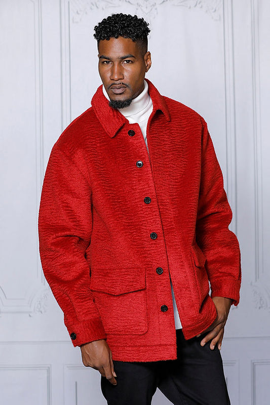 A man wearing the Insomnia "MANZINI CANADA" Red Short Ripple Faux Fur Button Coat over a white turtleneck stands against a white decorative wall.