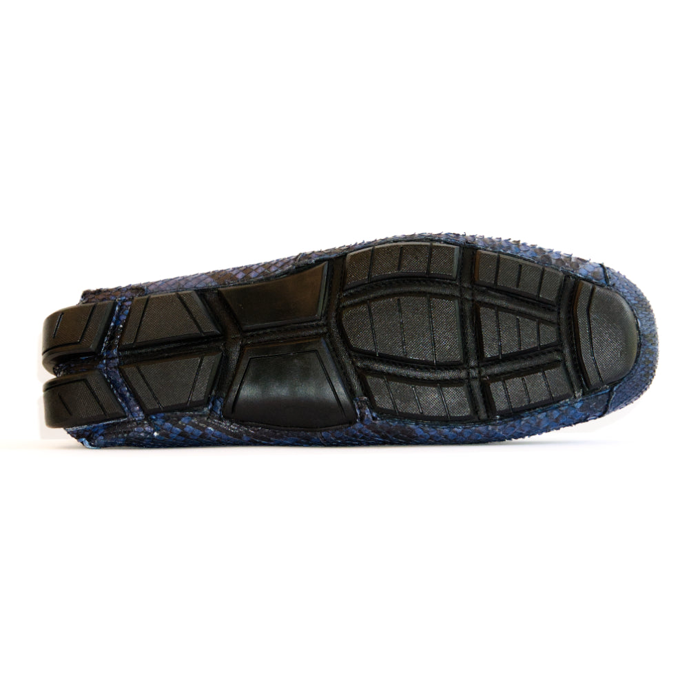 A pair of Capri Blue Jeans loafers by Marco Di Milano, crafted with a striking blue snakeskin texture; one shoe stands upright while the other lies on its side to reveal the black rubber sole—an elegant display of handcrafted luxury for those seeking exquisite exotic footwear.