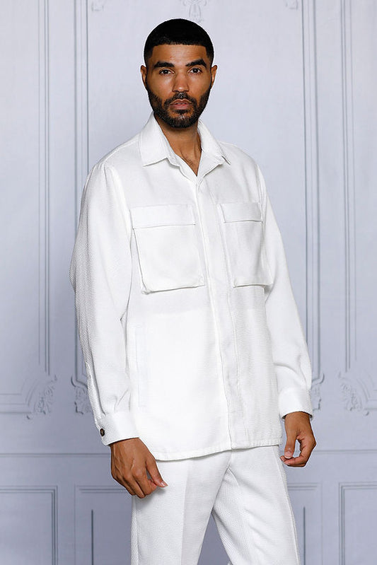 A man stands against a light-paneled wall wearing the INSOMNIA CAVALLI 2PC White Leisure Suit by Insomnia, featuring two large chest pockets and matching white pants—a refined take on casual attire.