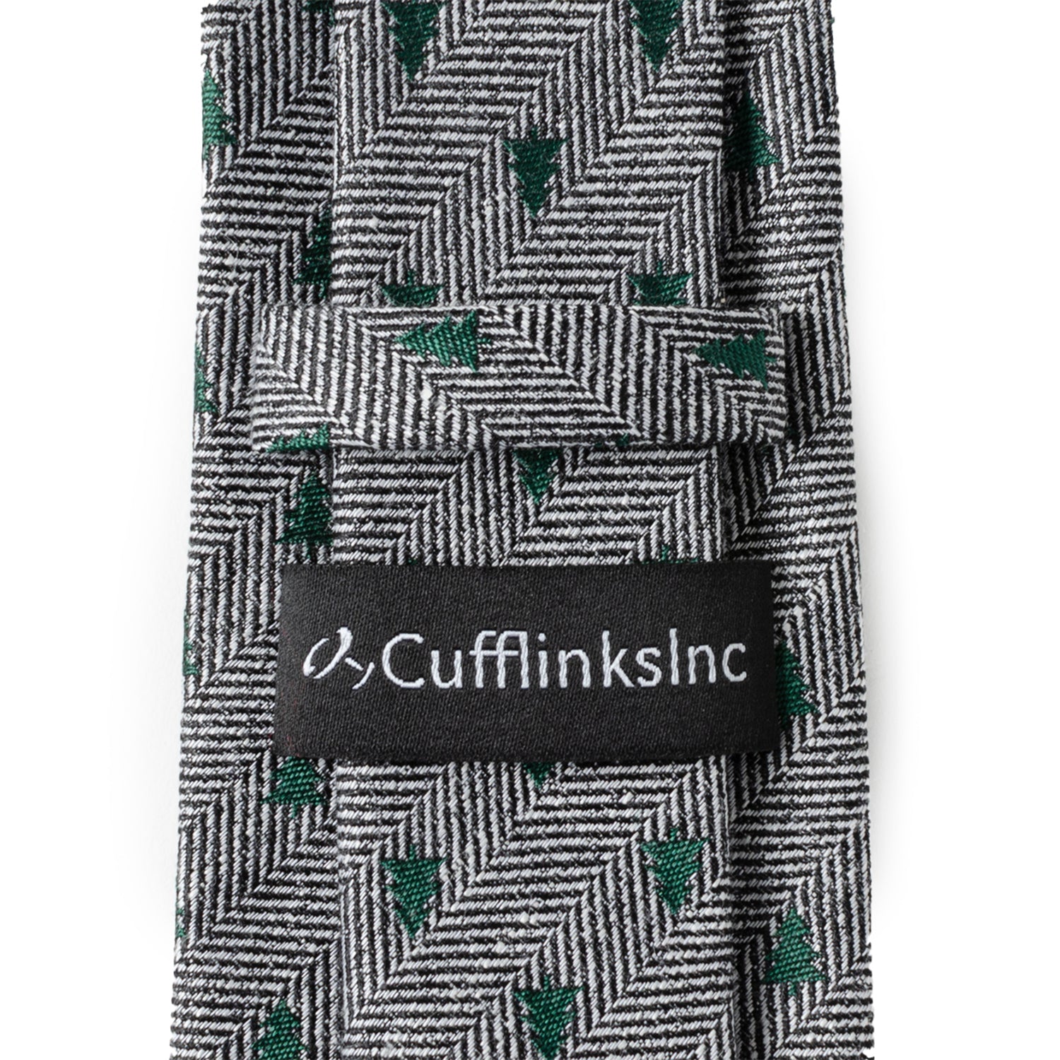 The Holiday Tree Herringbone Tie by Cufflinks.com features a black and white herringbone pattern adorned with small green tree motifs for a subtle, stylish look.
