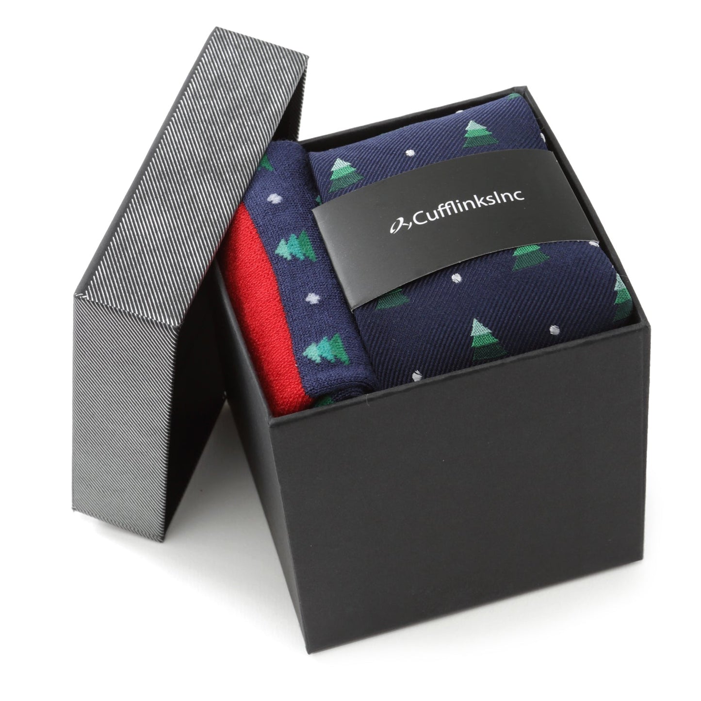 The Holiday Tree Tie and Sock Gift Set by Cufflinks.com includes a navy silk tie and matching socks with green Christmas trees, white dots, and festive red accents—making it a perfect holiday gift.