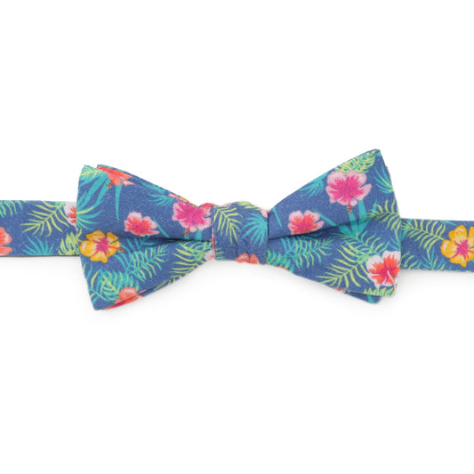 The Tropical Multi Men’s Bow Tie by Cufflinks.com features a colorful floral pattern with pink, yellow, and red flowers, green palm leaves, and vibrant hibiscus accents.