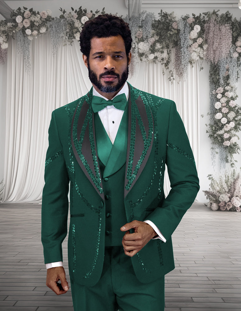 A man wears the STATEMENT CLOTHING | CHIC-HUNTER tuxedo by Statement Clothing, featuring a modern fit in hunter green with black accents, standing indoors before white drapes and floral arrangements.
