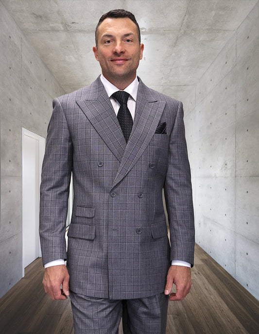 A man stands in a modern hallway wearing the STATEMENT CLOTHING | COPELO-BLACK suit by Statement Clothing, paired with a white shirt and black tie, looking directly at the camera.