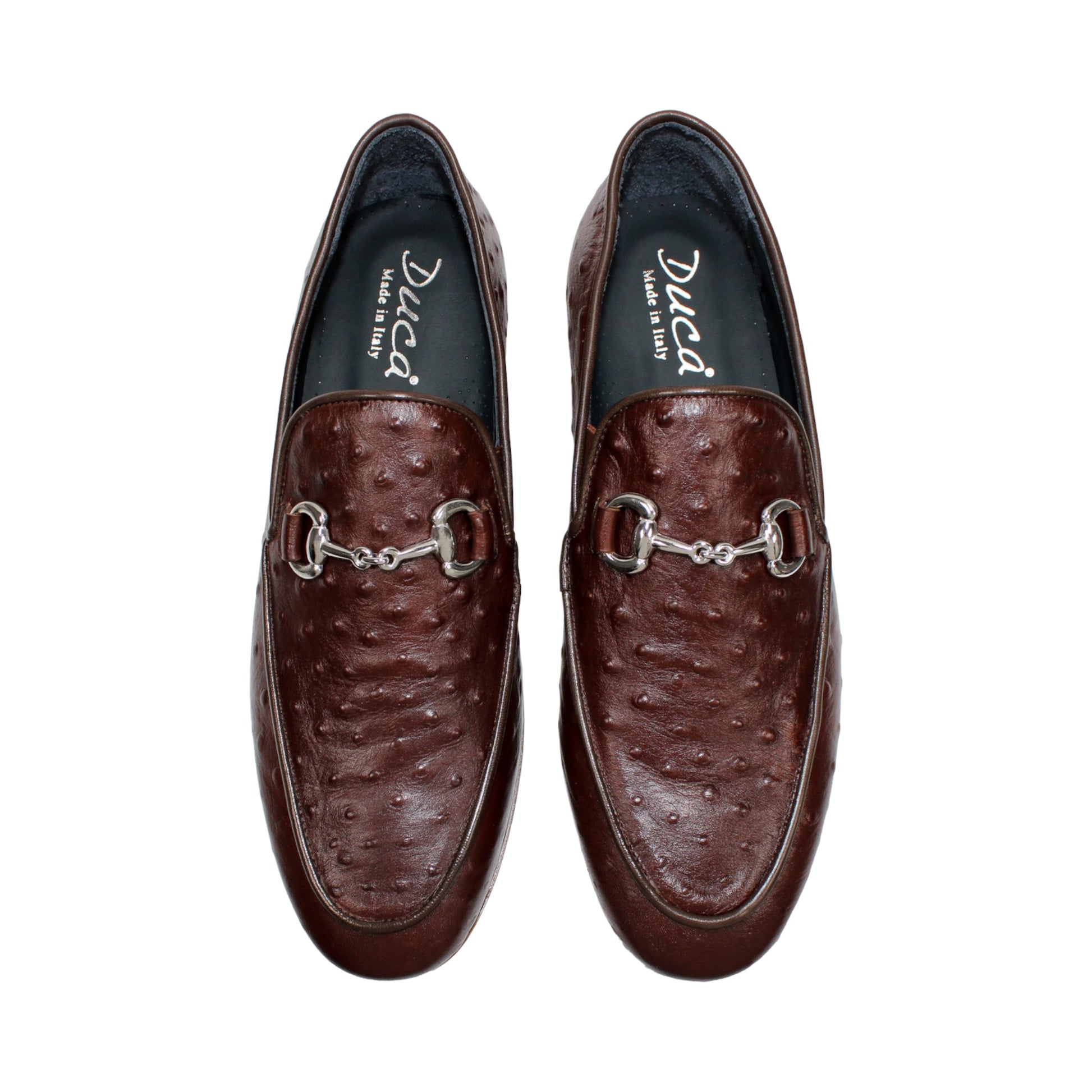 The Duca Di Matiste Duca Cortona Marrone features a luxurious brown leather loafer design with a textured Stampa Struzzo ostrich pattern, an elegant decorative metal bit on the upper, and a tan rubber sole. Displayed on a white background, this shoe exemplifies the finest Italian craftsmanship in men's luxury leather footwear.