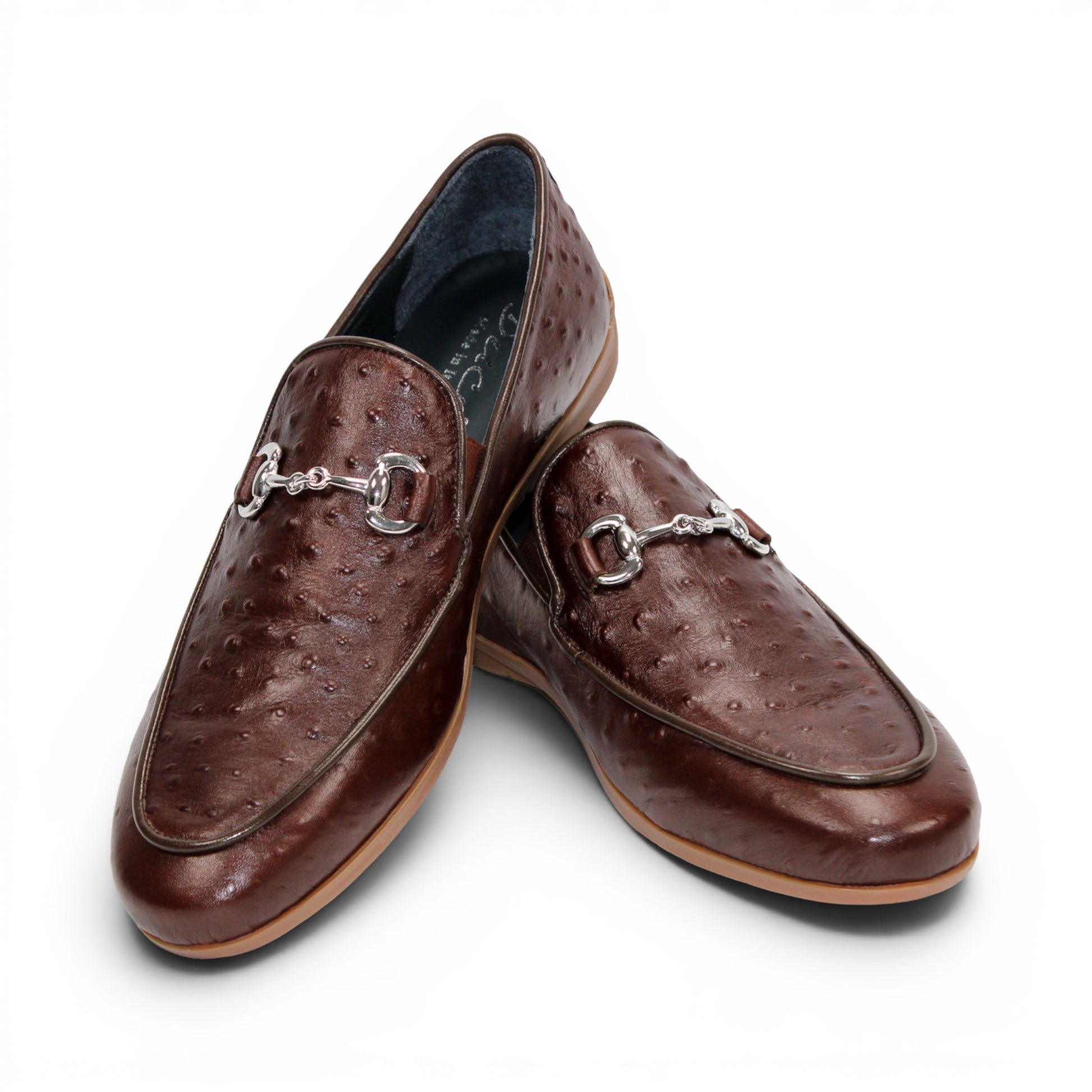 The Duca Di Matiste Duca Cortona Marrone features a luxurious brown leather loafer design with a textured Stampa Struzzo ostrich pattern, an elegant decorative metal bit on the upper, and a tan rubber sole. Displayed on a white background, this shoe exemplifies the finest Italian craftsmanship in men's luxury leather footwear.
