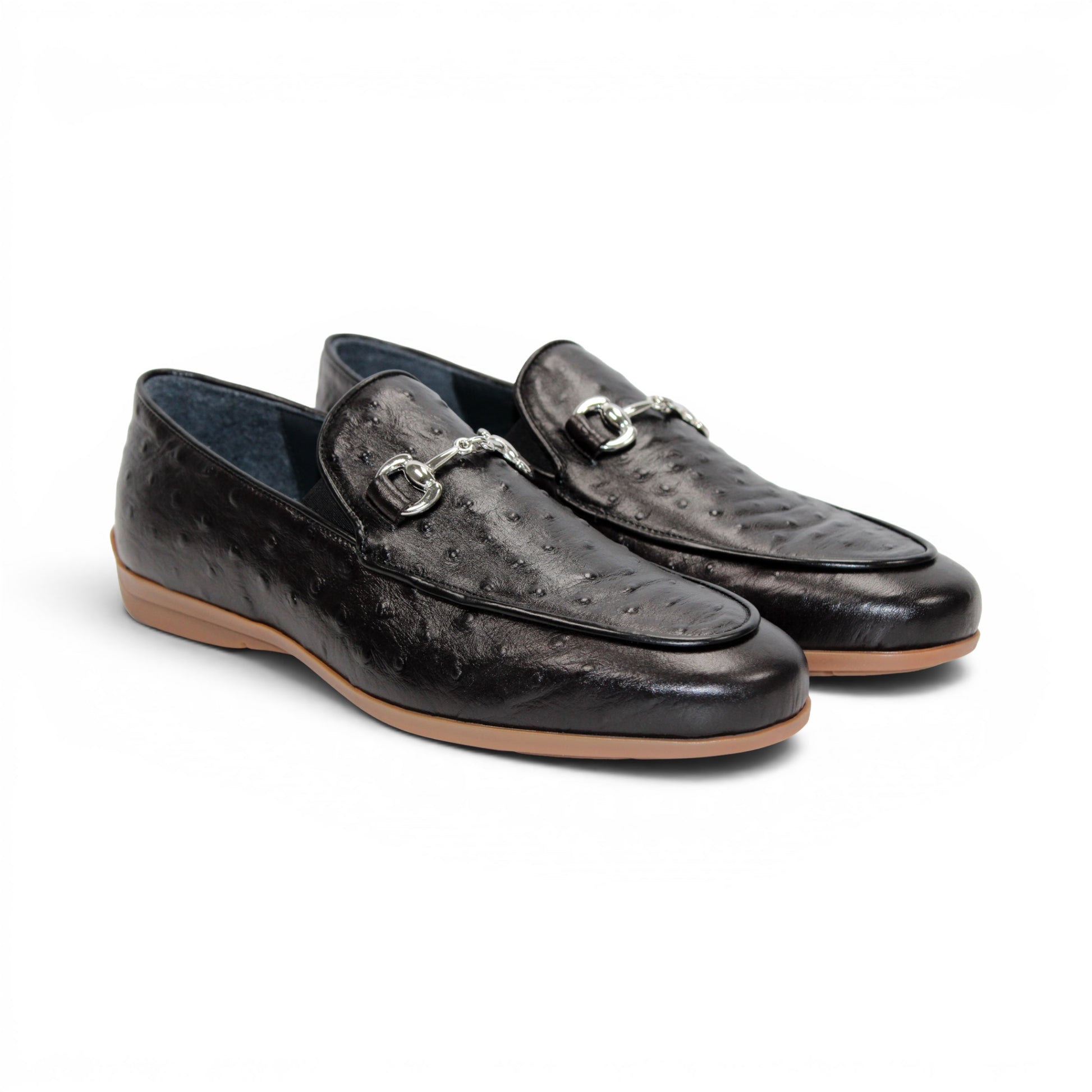 The Duca Cortona Black by Duca Di Matiste is a black Stampa Struzzo leather loafer, crafted in the style of a classic Italian shoe, featuring a silver buckle detail and a light brown rubber sole. Shown in profile on a white background, this refined design is an excellent choice for luxury footwear enthusiasts.
