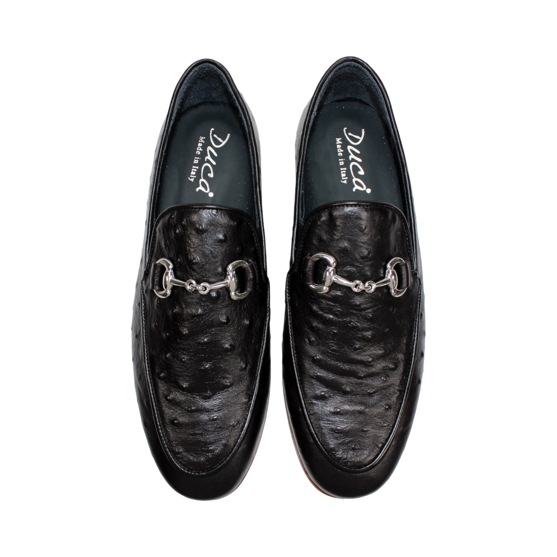 The Duca Cortona Black by Duca Di Matiste is a black Stampa Struzzo leather loafer, crafted in the style of a classic Italian shoe, featuring a silver buckle detail and a light brown rubber sole. Shown in profile on a white background, this refined design is an excellent choice for luxury footwear enthusiasts.