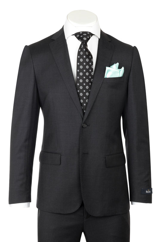 A mannequin showcases the CANALETTO PORTO Slim Fit, Charcoal Gray Pure Wool Suit by REDA Cloth CRS901, paired with a white shirt, black patterned tie, and light blue pocket square—an elegant example of luxury menswear.