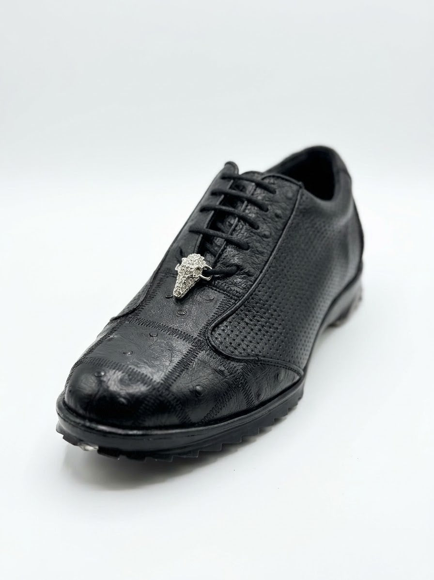The Los Altos Avestruz Perforated Ostrich Lace Up Casuals in Black feature a textured black leather upper reminiscent of exotic skin, detailed with laces and a metallic bull head ornament near the tongue, presented against a plain white background.