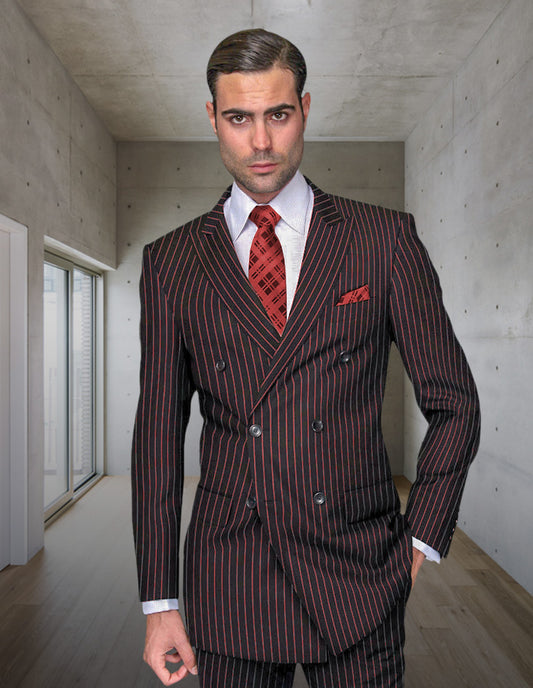 A man wears the STATEMENT CLOTHING | DB-ZARELLI-BLACK RED double-breasted suit by Statement Clothing, featuring regular fit pleated pants and a red tie, standing in a modern room with concrete walls and a wooden floor.
