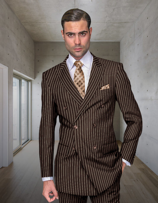 A man in the STATEMENT CLOTHING | DB-ZARELLI-BROWN double-breasted suit by Statement Clothing stands in a modern, minimalist room with concrete walls and wooden floors.