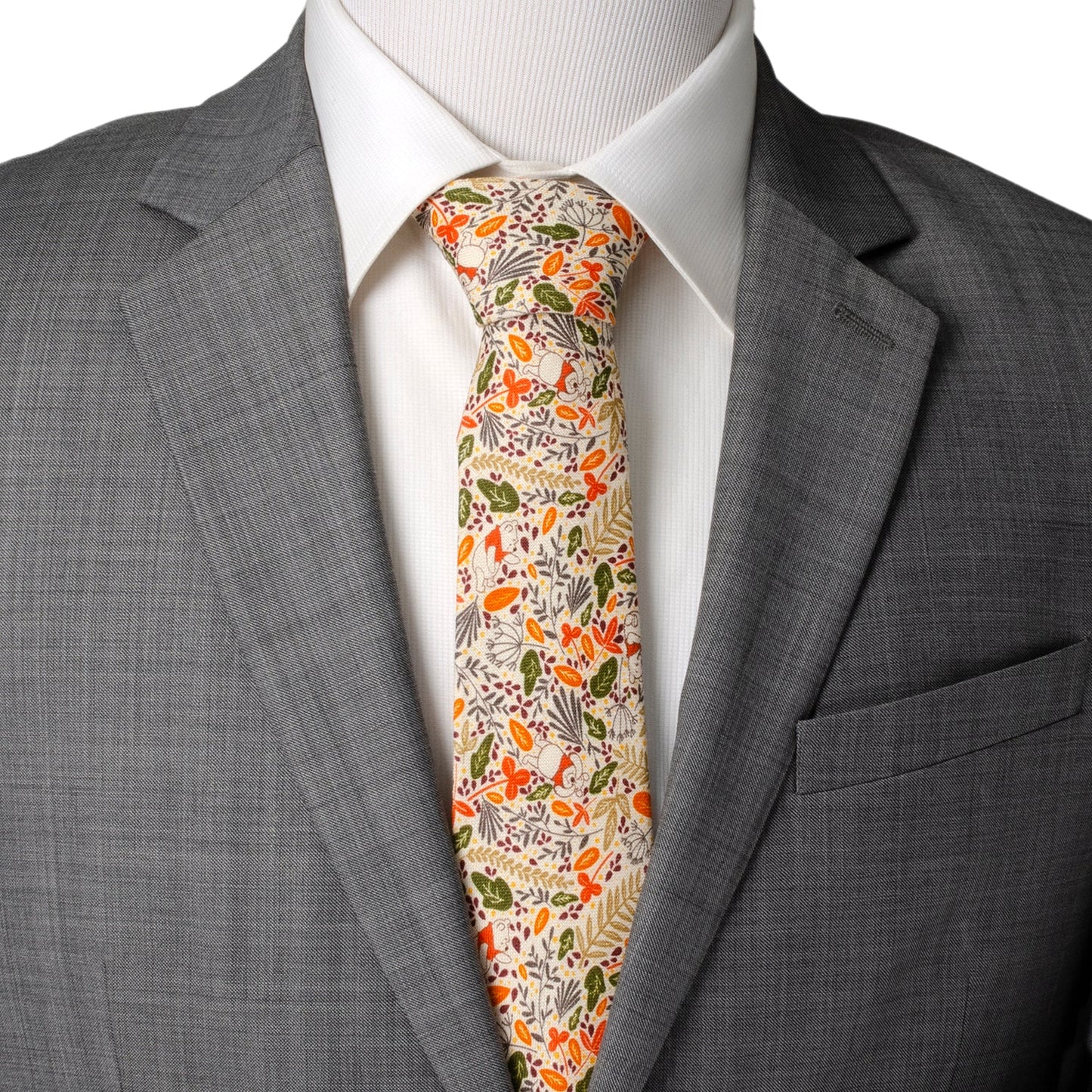 The Disney Winnie the Pooh Tan Patterned Men's Tie by Cufflinks.com features a beige background with autumn leaves in orange, yellow, green, and brown, plus subtle animal illustrations.