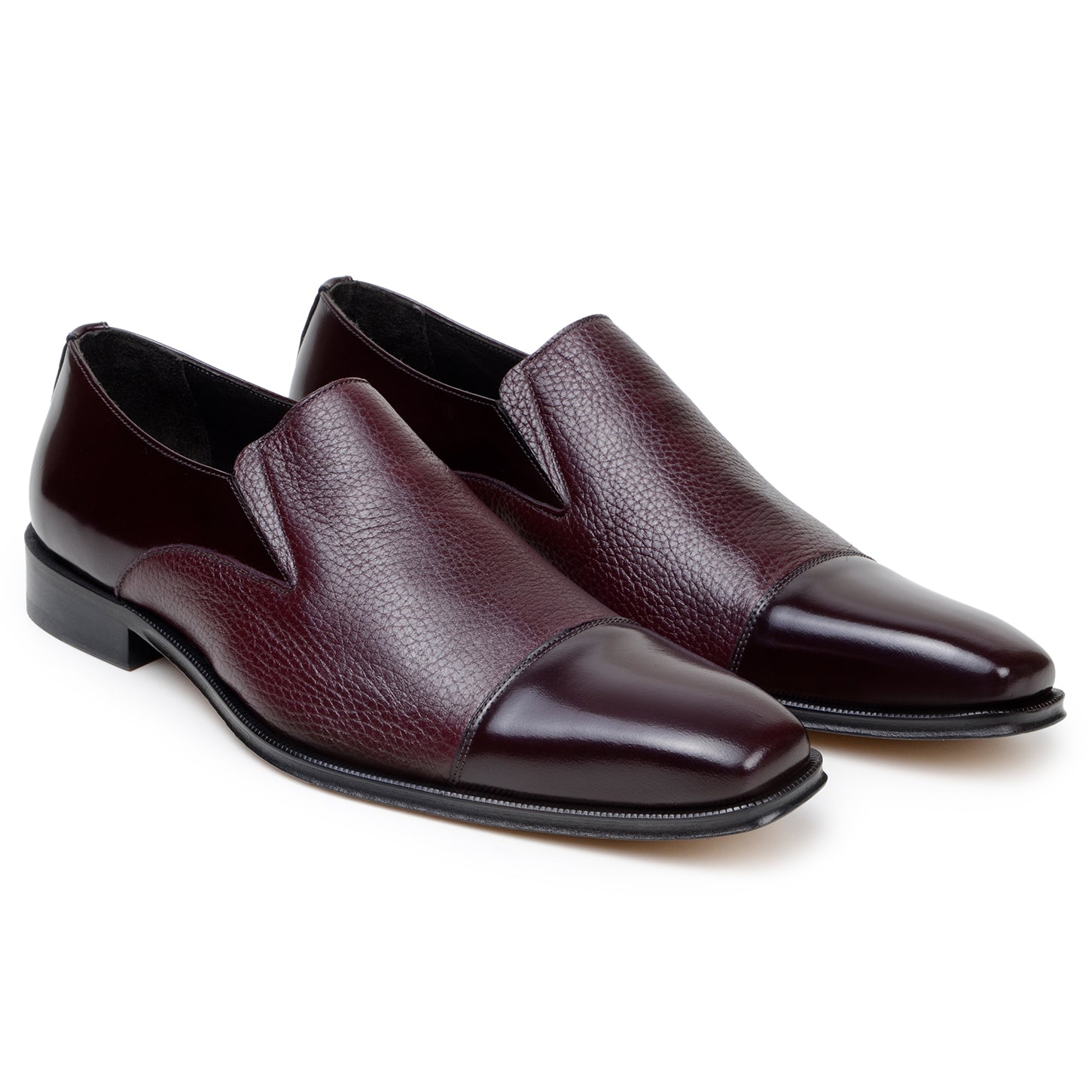 The BELVEDERE Andreo is a genuine Italian deerskin and calf burgundy dress shoe, featuring a slip-on design, low black heel, and mixed smooth-textured finishes—crafted for style and comfort.
