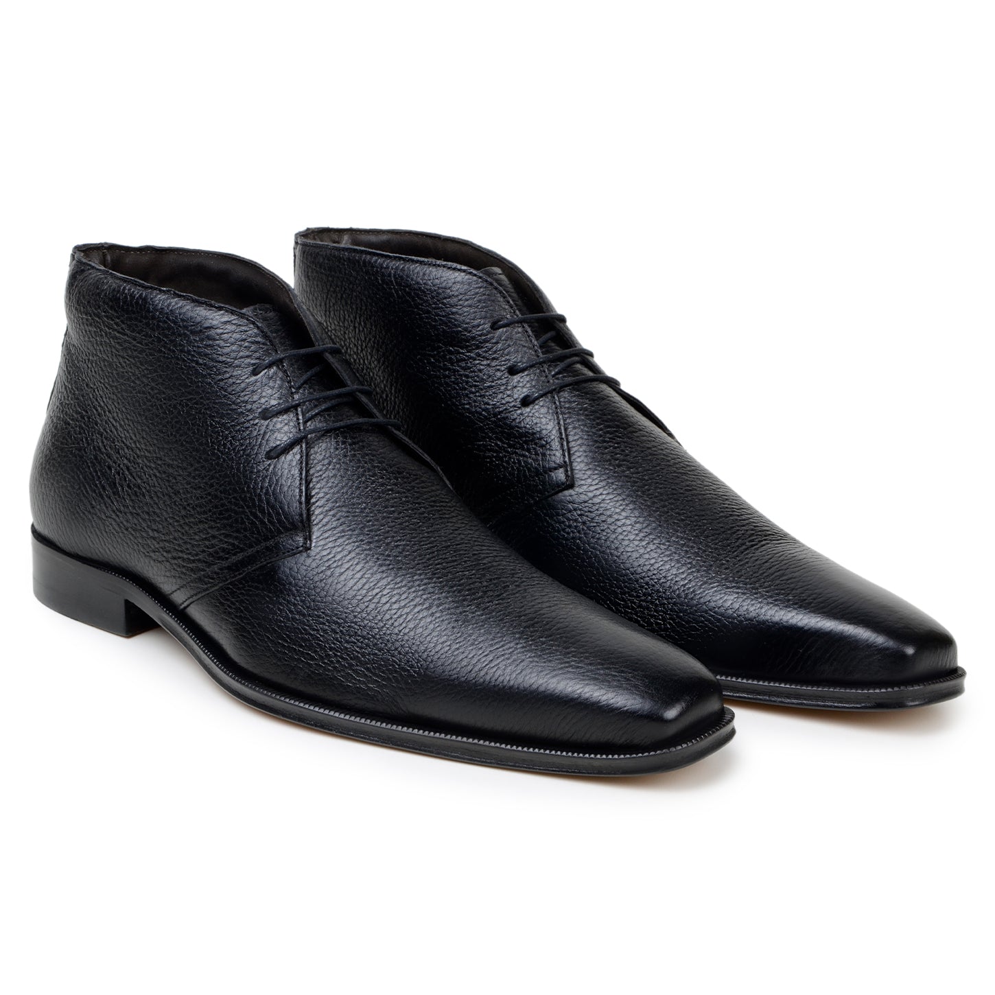The BELVEDERE Axel is a black genuine Italian deerskin boot with a textured finish, minimal stitching, and a low heel, handcrafted in Brazil and shown in profile against a white background.