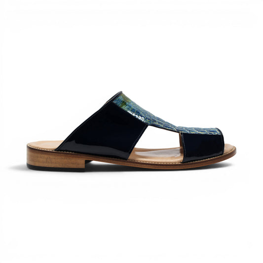 A side view of the Fennix Diego Blue sandal by Fennix of Italy, featuring a wooden sole, black patent leather sides, and a textured blue upper with intricate cut-out detailing—exemplifying the exotic luxury typical of Italian craftsmanship.