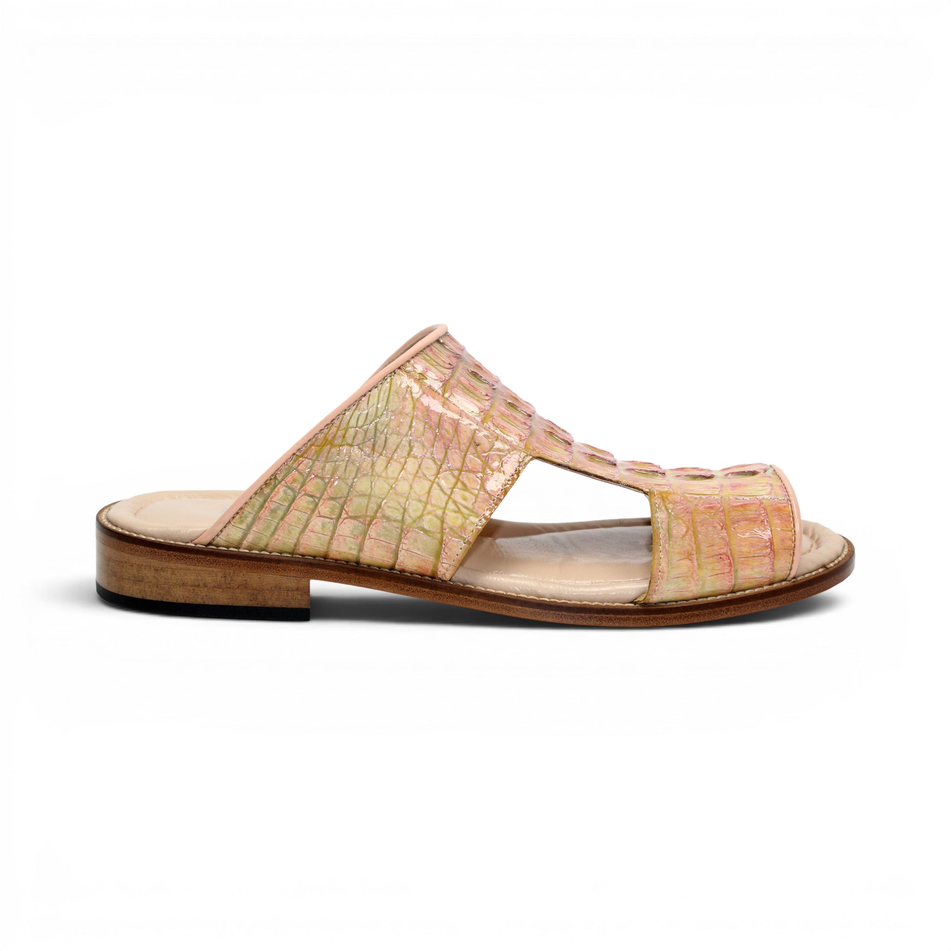 The Fennix Diego Pink by Fennix of Italy is a flat open-toe sandal crafted from genuine alligator leather in a striking pink and yellow crocodile pattern, featuring cut-out details and a low wooden heel for an exotic touch of luxury, shown in profile against a white background.