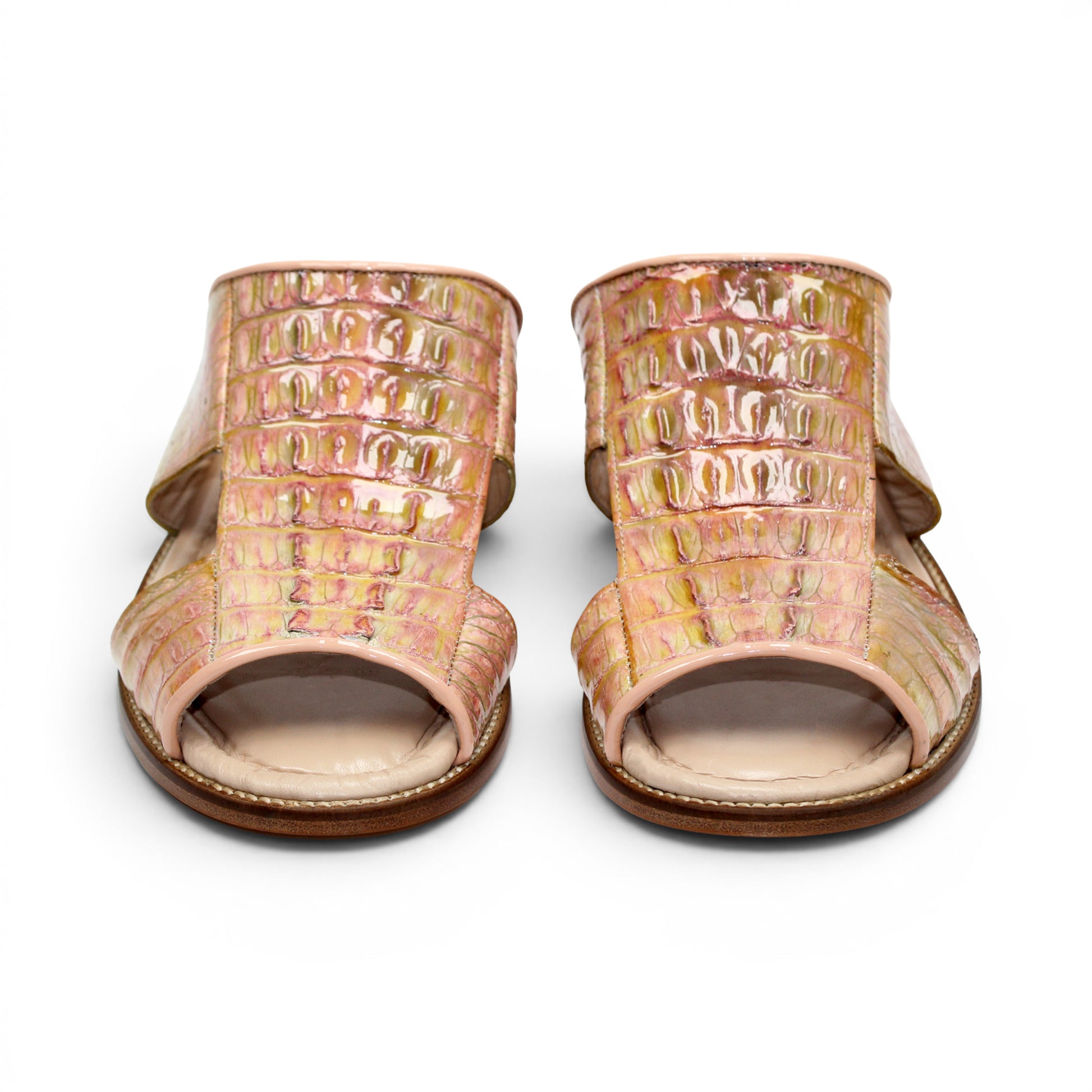 The Fennix Diego Pink by Fennix of Italy is a flat open-toe sandal crafted from genuine alligator leather in a striking pink and yellow crocodile pattern, featuring cut-out details and a low wooden heel for an exotic touch of luxury, shown in profile against a white background.