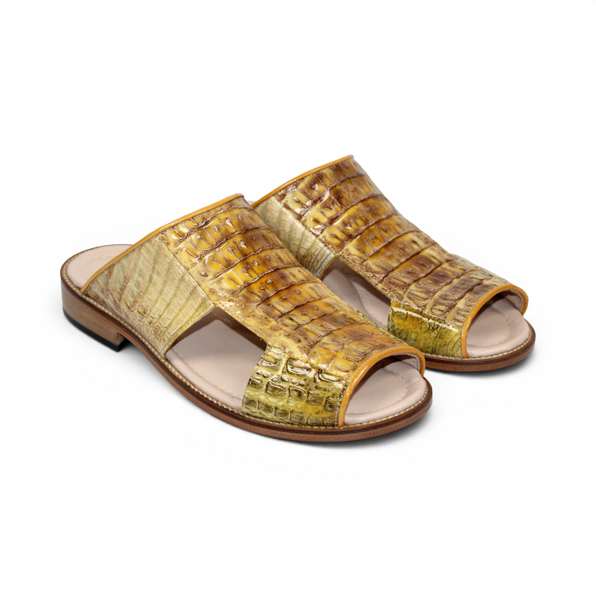 The Fennix Diego Yellow slide sandal by Fennix of Italy features yellow crocodile-embossed leather, an open toe, a wide strap, and a flat wooden sole—an eye-catching piece of exotic footwear inspired by Italian-made luxury shoes, shown from the side against a white background.