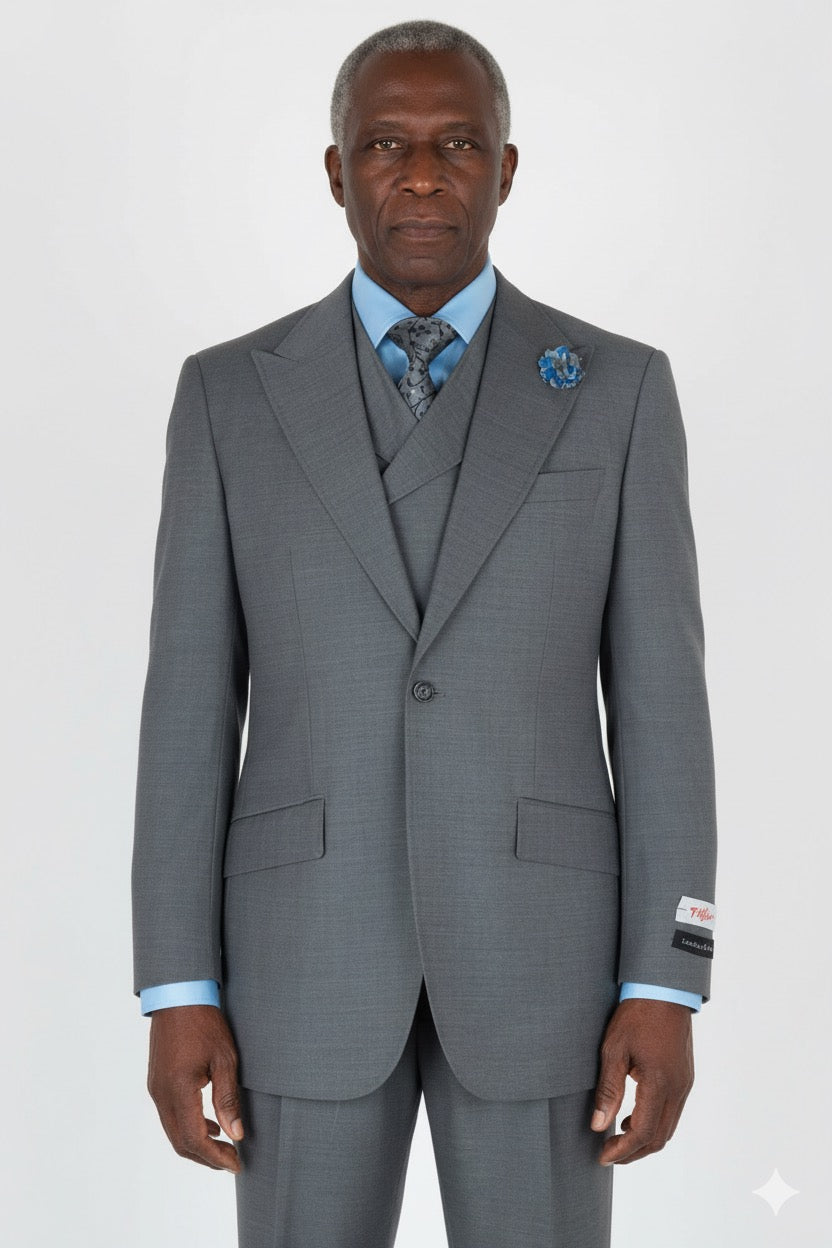 This Tiglio Rosso San Giovesse Light Grey E09063/26 suit, paired with a blue shirt and patterned tie, exudes refined elegance. The custom-made piece is enhanced with a floral lapel pin, making it a sophisticated choice for any occasion.