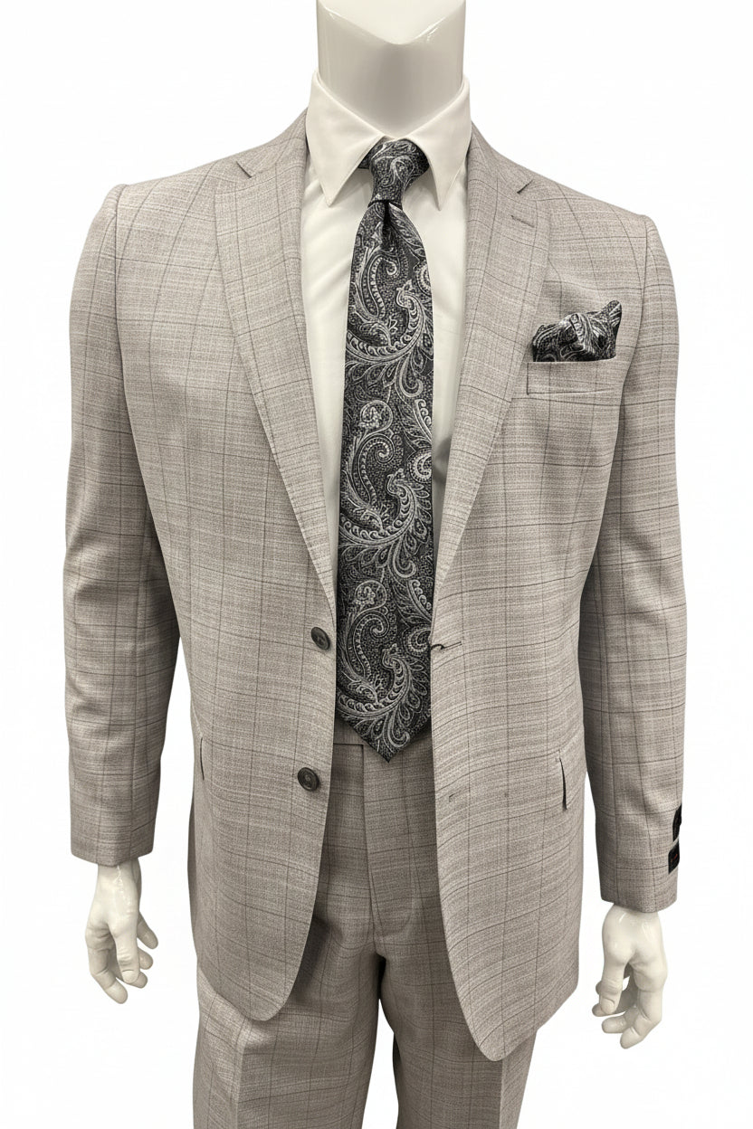 A mannequin dressed in the Tiglio Luxe Dolcetto Modern Fit Wool Suit TL7041—a light gray plaid pure wool suit—paired with a white shirt, paisley-patterned tie, and matching pocket square, is displayed in-store among expertly tailored men’s clothing by Tiglio Luxe.