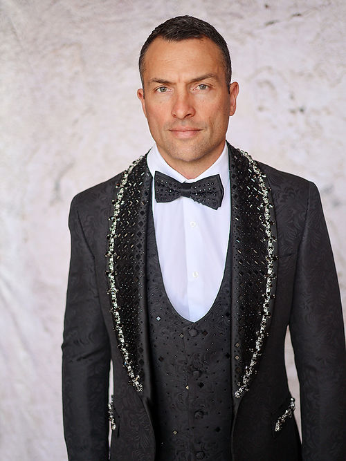 A man in an Insomnia MANZINI ENZO 3-piece slim fit suit with a rhinestone woven pattern jacket and bow tie stands against a light background.