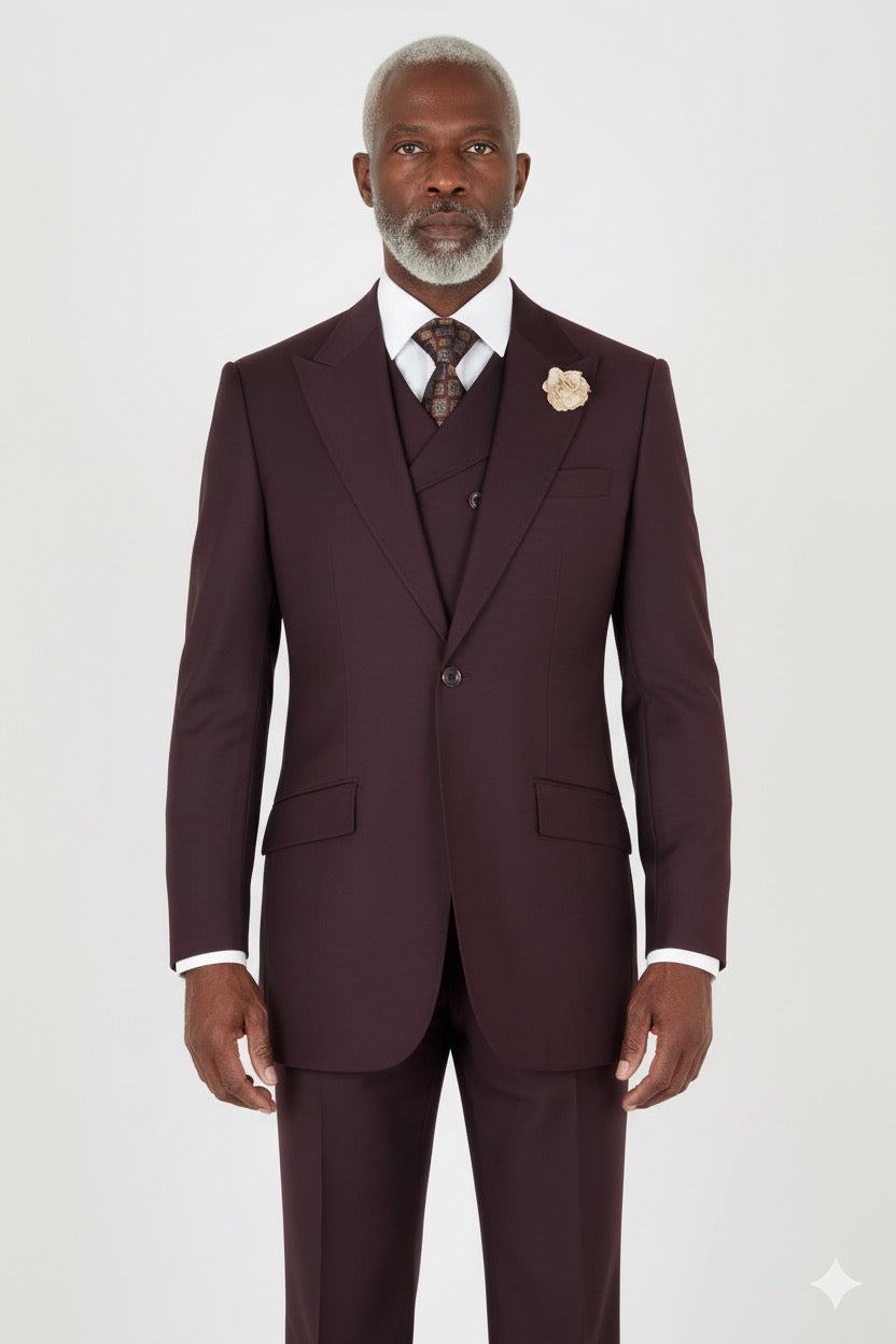 A Tiglio Rosso San Giovesse Burgundy three-piece suit with a white dress shirt, patterned tie, and cream boutonniere.