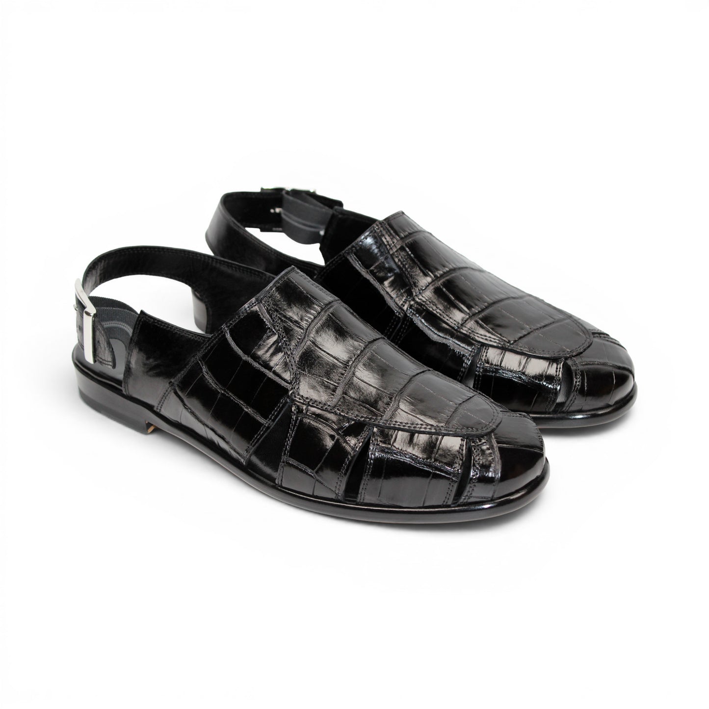 Introducing the Fennix F131 Black sandal by Fennix of Italy—a black leather design featuring a closed toe, open heel, silver buckle strap, and a flat sole, elegantly displayed on a white background. Crafted for those who value luxury footwear, this sandal offers refined style and comfort with every step.