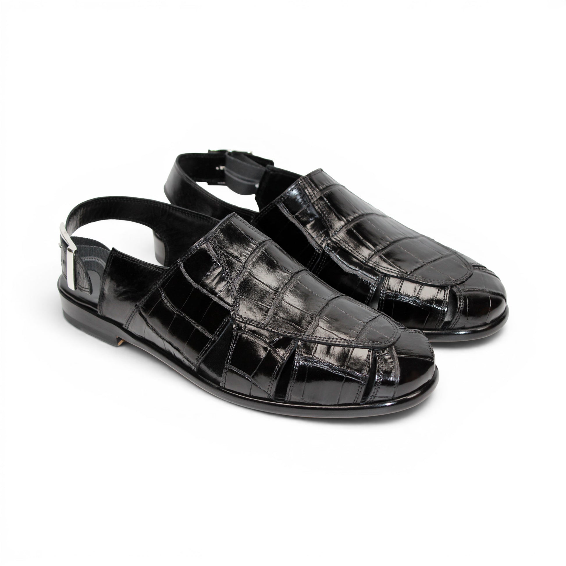 Introducing the Fennix F131 Black sandal by Fennix of Italy—a black leather design featuring a closed toe, open heel, silver buckle strap, and a flat sole, elegantly displayed on a white background. Crafted for those who value luxury footwear, this sandal offers refined style and comfort with every step.