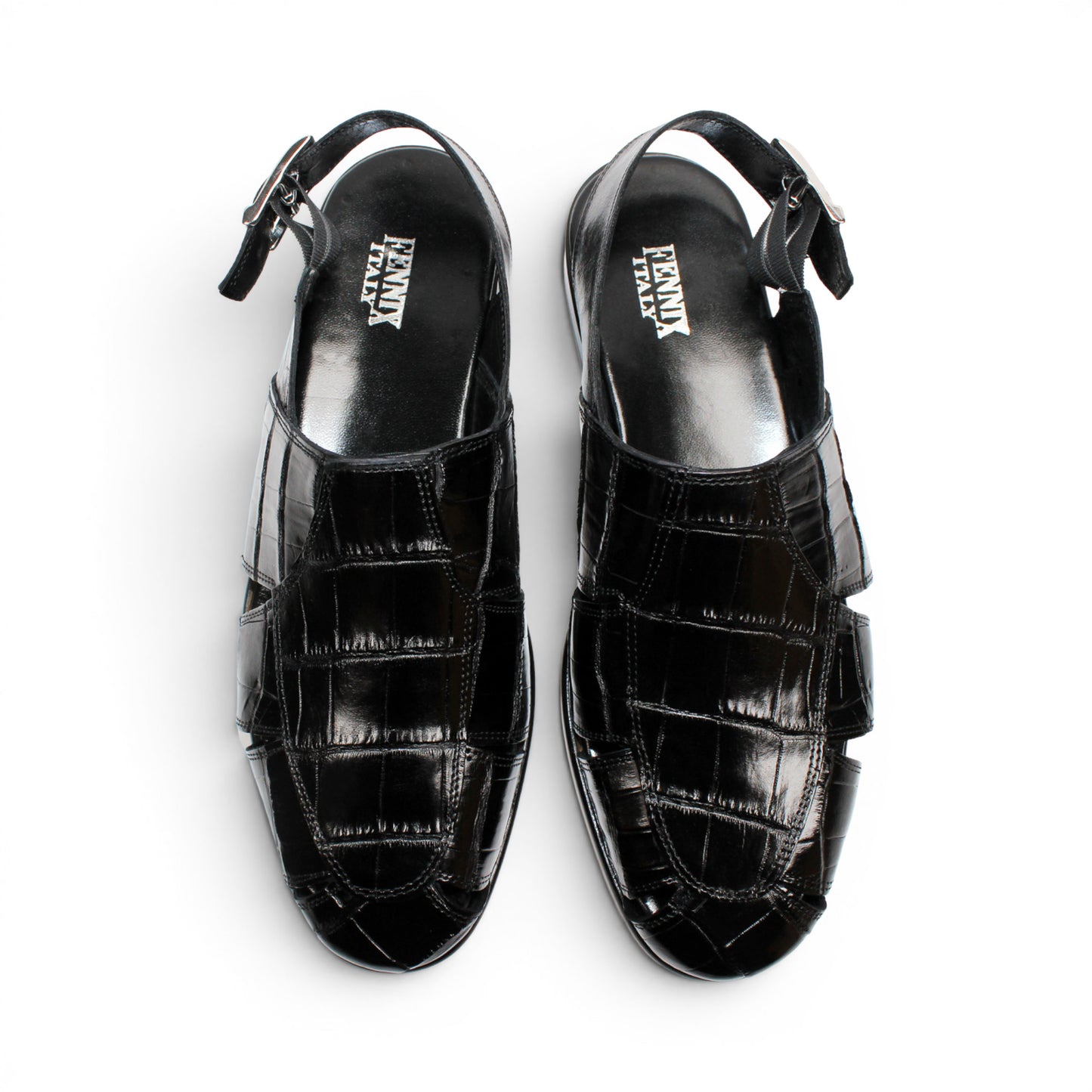 Introducing the Fennix F131 Black sandal by Fennix of Italy—a black leather design featuring a closed toe, open heel, silver buckle strap, and a flat sole, elegantly displayed on a white background. Crafted for those who value luxury footwear, this sandal offers refined style and comfort with every step.