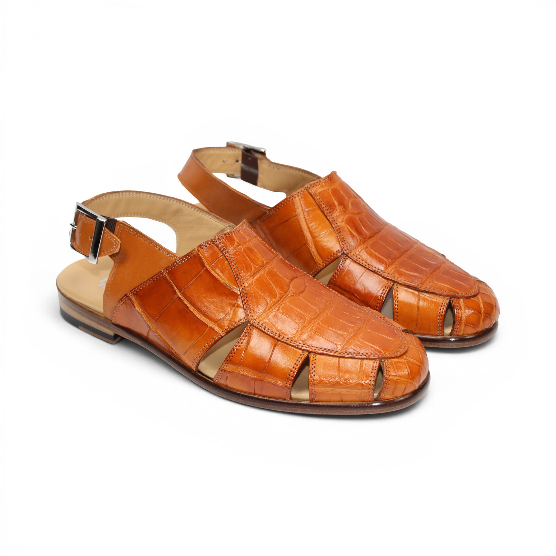 The Fennix F131 Cognac sandal by Fennix of Italy is an open-toe design crafted from genuine alligator leather in a rich brown hue, featuring elegant cut-outs, a slingback strap with side buckle, and a low flat heel—perfect for those who appreciate true luxury footwear. Displayed on a white background.