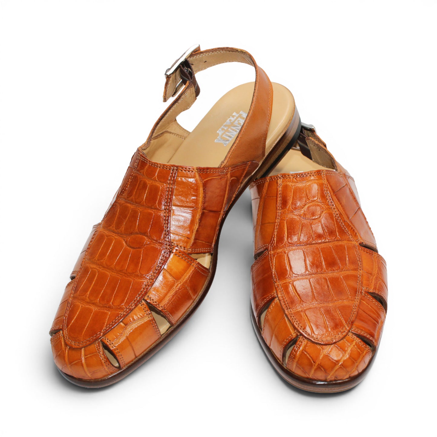 The Fennix F131 Cognac sandal by Fennix of Italy is an open-toe design crafted from genuine alligator leather in a rich brown hue, featuring elegant cut-outs, a slingback strap with side buckle, and a low flat heel—perfect for those who appreciate true luxury footwear. Displayed on a white background.